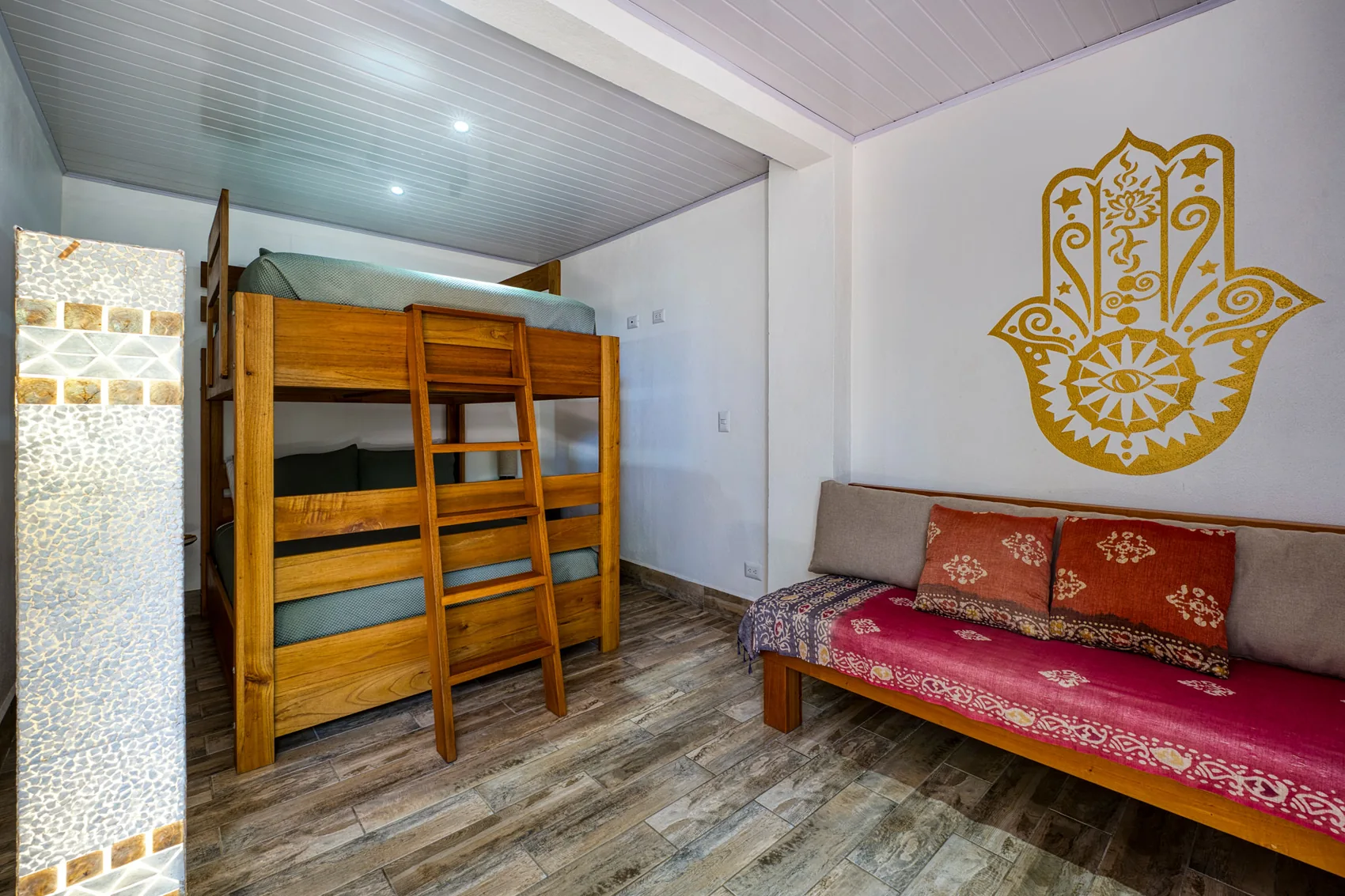 Hamsa: bunk beds under a gold hand mural