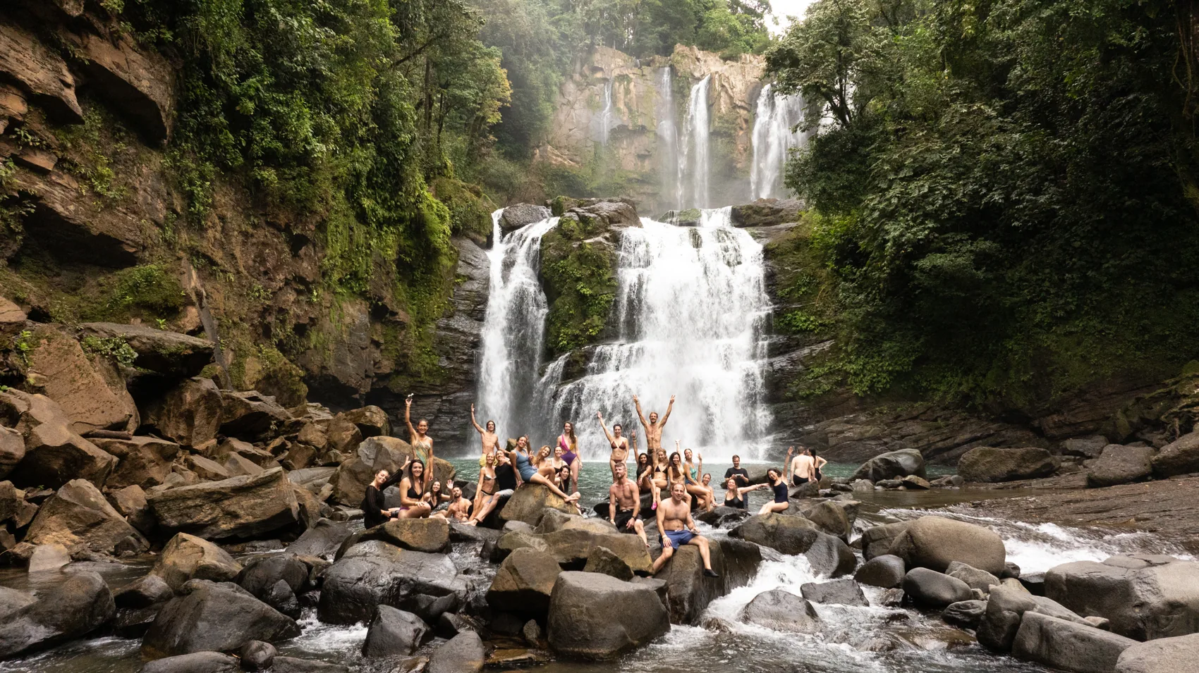 Un grupo de retiro sobre las rocas al pie de una catarata